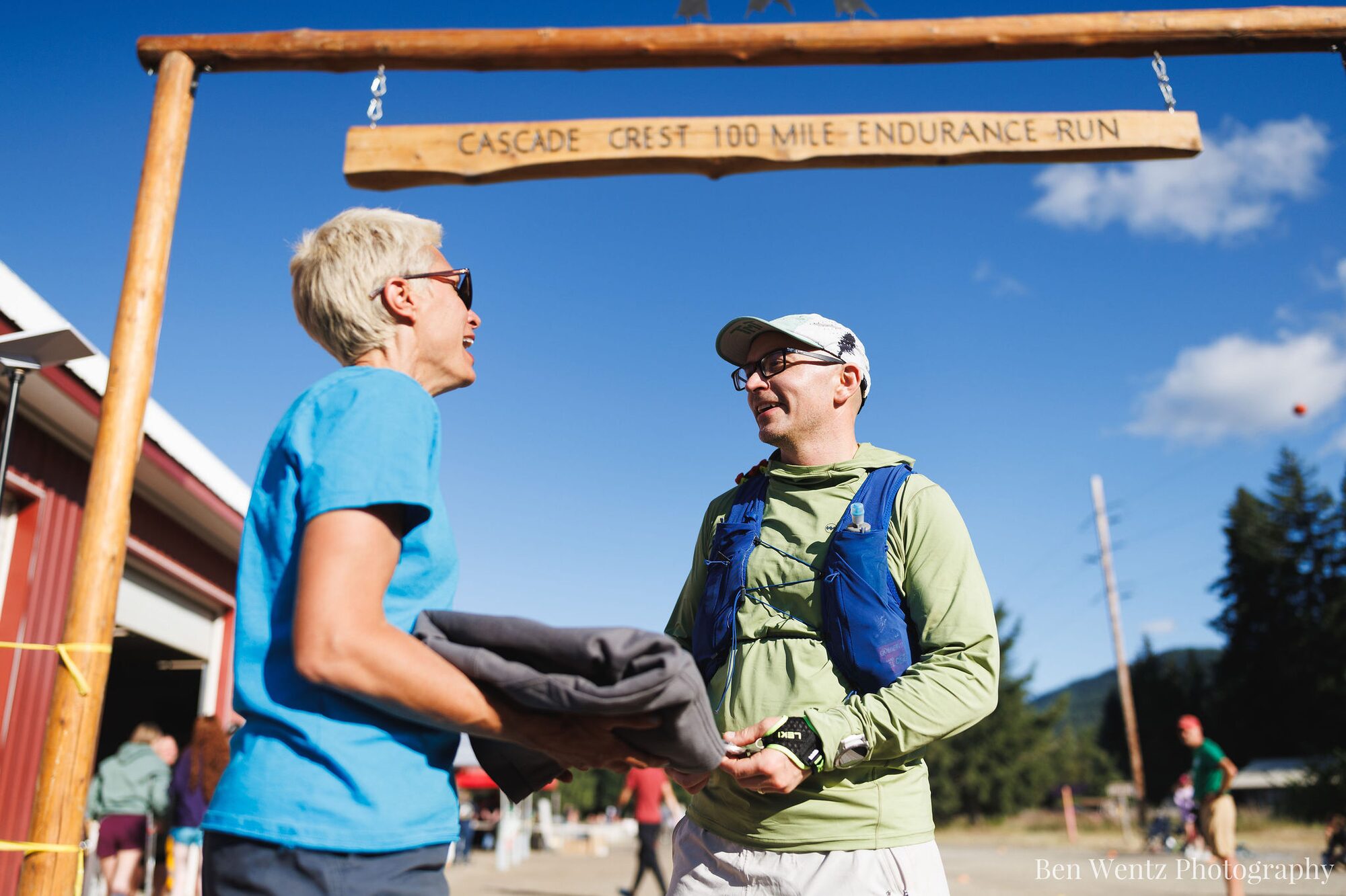 Wade receiving his finisher sweatshirt beneath the Cascade Crest finish sign